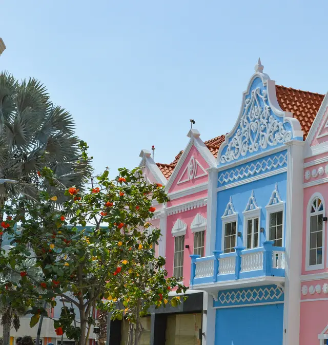 Pastel Dutch colonial-style buildings in downtown Oranjestad, Aruba, under a clear blue sky