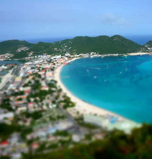 Aerial view of the curved beach and turquoise waters of Great Bay at Philipsburg, Sint Maarten, with a cruise ship at the pier
