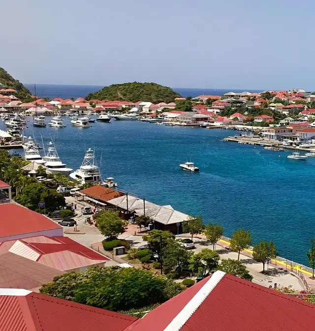 Gustavia harbour in Saint-Barthélemy, with moored boats and red-roofed buildings around the bay